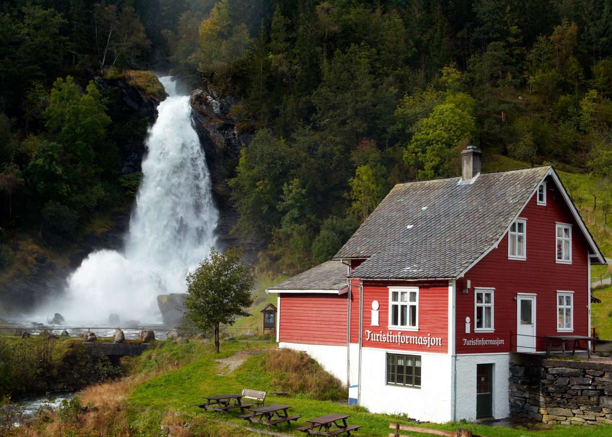 Tradycyjny norweski domek na tle wodospadu (Norwegia) puzzle ze zdjęcia