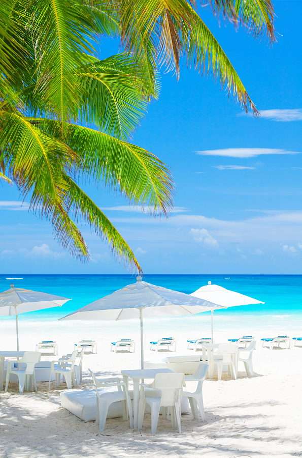 Stoliki pod parasolami na tropikalnej plaży puzzle online ze zdjęcia