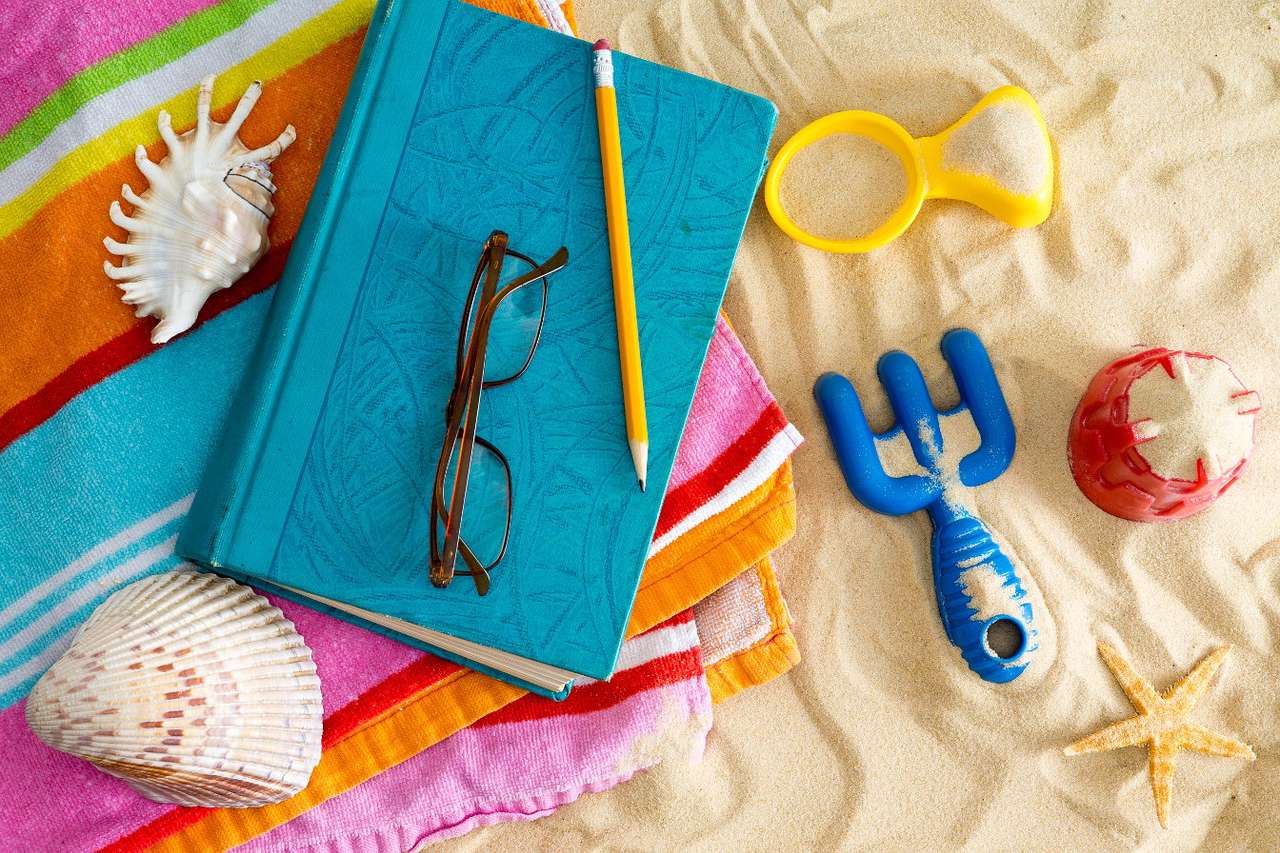 Książka i okulary na plażowym ręczniku puzzle